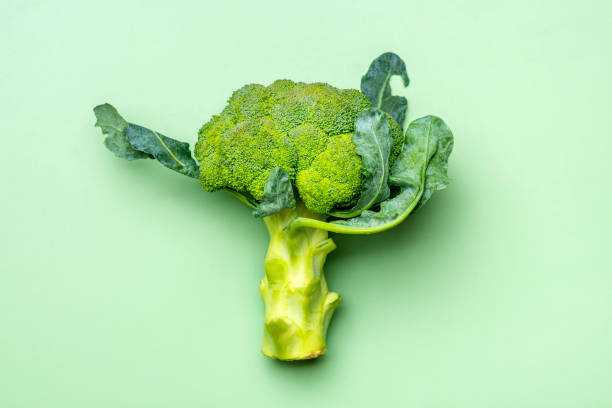 istock Fresh Harvested cabbage broccoli on trend green background. Vegetables vitamin C Natural Organic broccoli lies on green table Top View Flat Lay 1352233373
