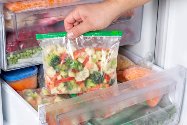 istock Plastic bags with different frozen vegetables in refrigerator. 1352233467
