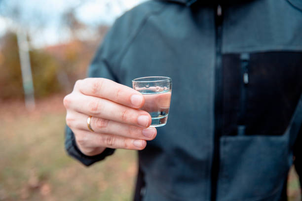 man hand with shot drink outdoors - toast glass cut out human hand imagens e fotografias de stock