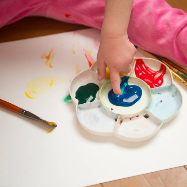 istock Girl with Down syndrome covered in paint when drawing 1352236177