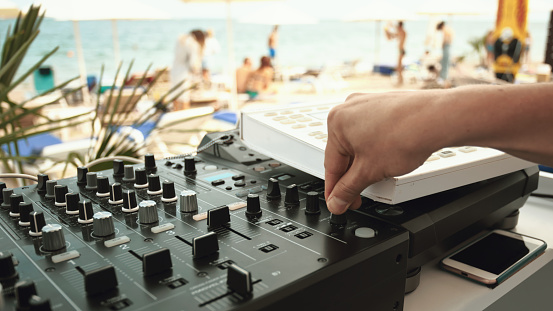 DJ equipment and large group of people on the blurred background