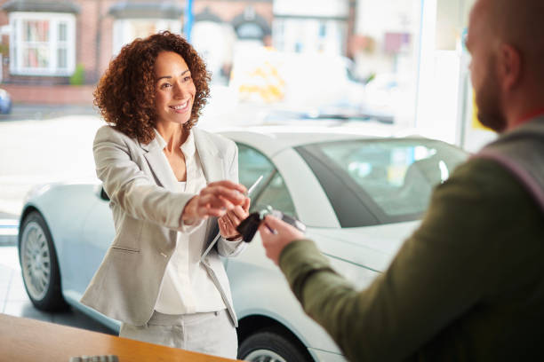 car sales person handing over keys car sales person shanding over car rent a car stock pictures, royalty-free photos & images