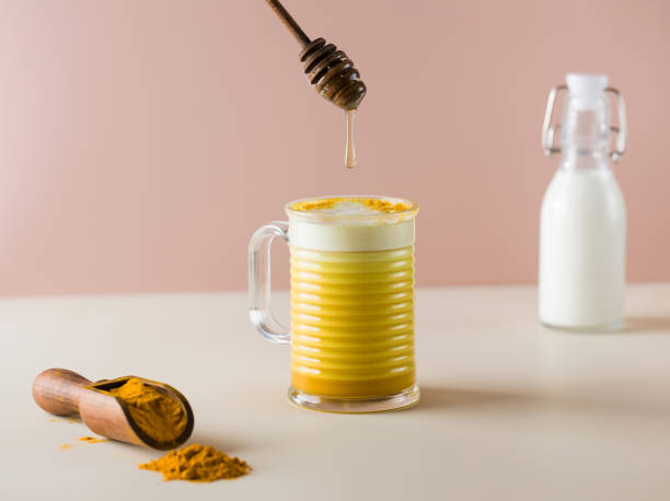 istock A drop of honey drips into a latte turmeric mug. Moon milk for better sleep. 1352238106