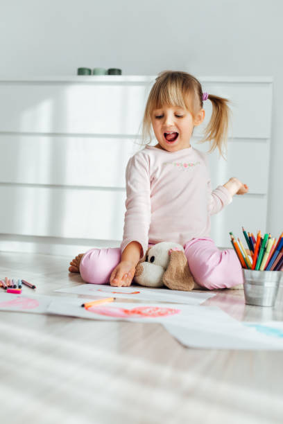 istock Little Girl Drawing At Home 1352239196