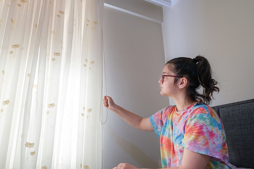 sun shining from house window of a young girl who opens the window to lighting the room for daily life sun shining concepts