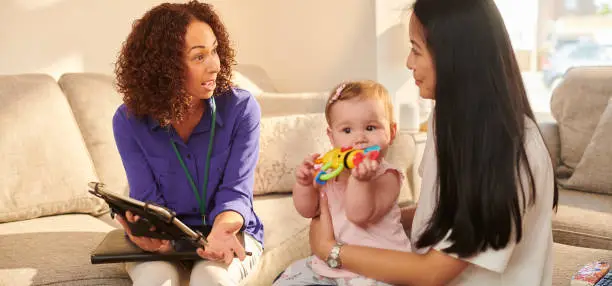 Photo of official chatting to young mother