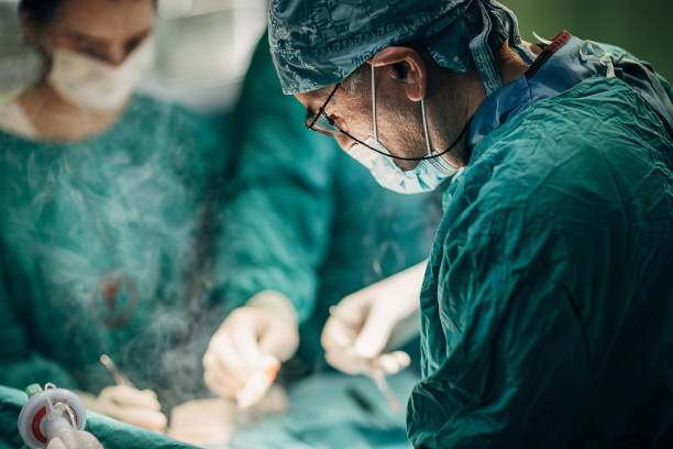 Team of surgeons performing surgery stock photo
