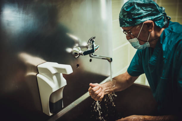 istock Male surgeon washing hands before operation 1352244215