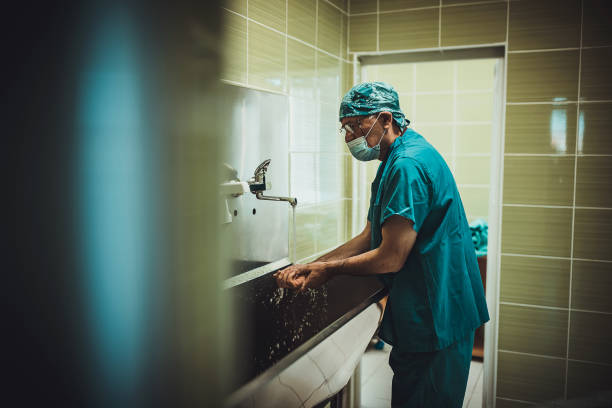 cirujano masculino que se lava las manos antes de la operación - scrubbing up fotografías e imágenes de stock