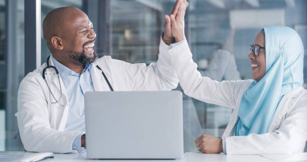 Shot of two medical professionals giving each other a high five in an ofice at work stock photo