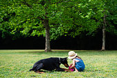 芝生の上で遊ぶ小さな女の子とドーベルマン