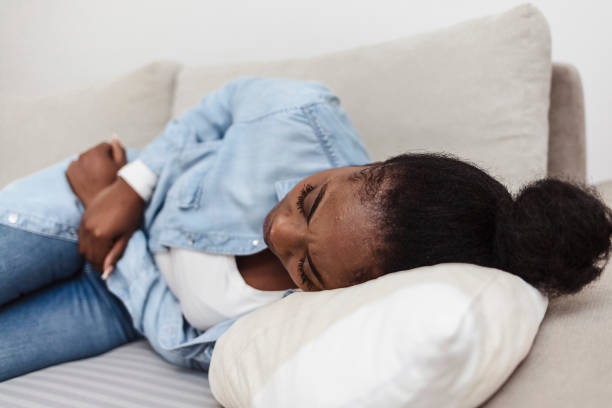 istock Woman in painful expression holding hands against belly. 1352246492