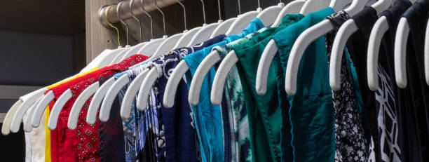 home closet organized by color with hangers aligned - department store imagens e fotografias de stock