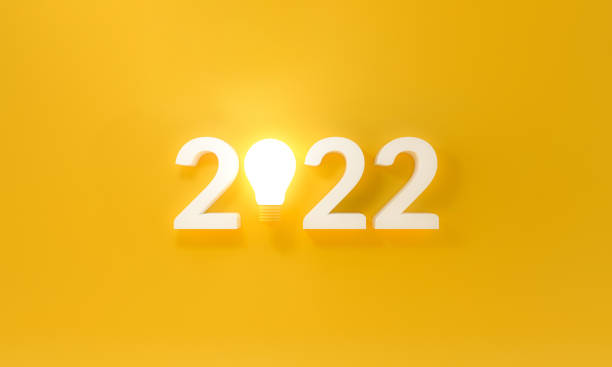 istock Bulb light with new year 2022 on yellow background. 1352247566
