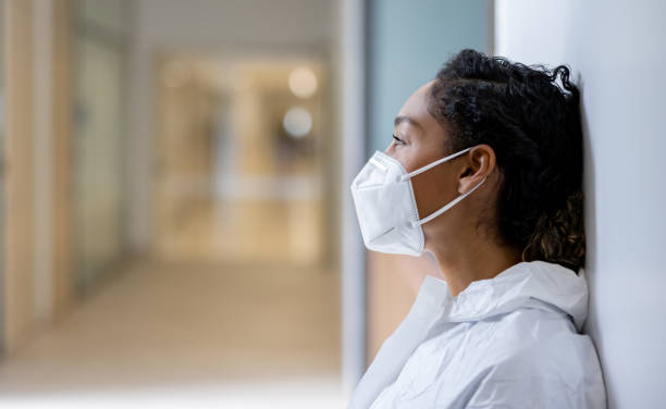 Healthcare worker taking a break while working at the hospital during the pandemic African American healthcare worker taking a break while working at the hospital during the COVID-19 pandemic - healthcare and medicine concepts frontline worker mask stock pictures, royalty-free photos & images