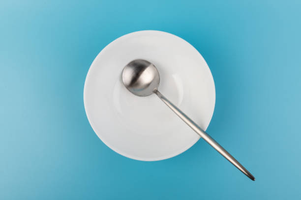 istock Empty plate with spoon on blue background. Flat lay Dishes for breakfast, lunch or dinner Mock up 1352251584