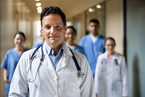 Portrait of a Latin American doctor leading a group of healthcare workers at the hospital and looking at the camera smiling â medicine concepts