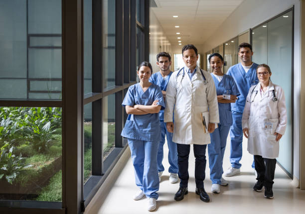 Team of doctors and nurses working at the hospital Happy Latin American team of doctors and nurses working at the hospital and looking at the camera smiling - healthcare and medicine concepts civilian stock pictures, royalty-free photos & images