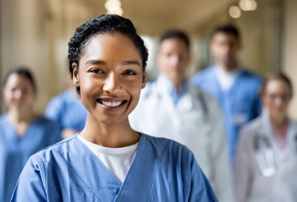 szczęśliwa naczelna pielęgniarka pracująca w szpitalu z grupą pracowników służby zdrowia - portrait doctor paramedic professional occupation zdjęcia i obrazy z banku zdjęć