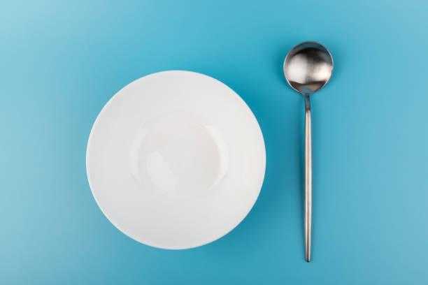 istock Empty plate with spoon on blue background. Flat lay Dishes for breakfast, lunch or dinner Mock up 1352252359