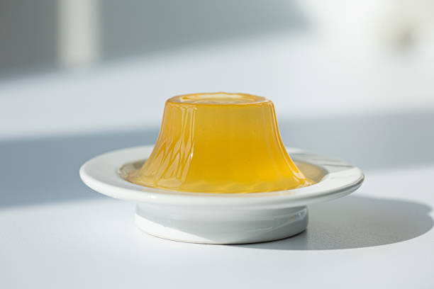 istock orange gelatin jelly in a plate isolated on a white background. 1352254096