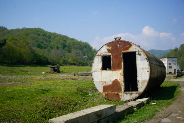 großer runder verlassener container auf der wiese - old station natural gas russia stock-fotos und bilder