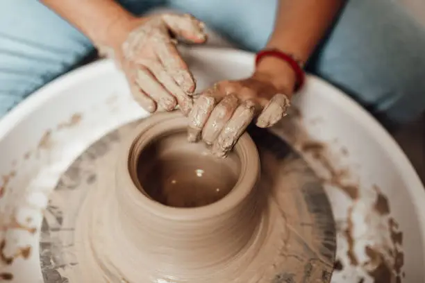 A young woman works in a clay pots workshop.