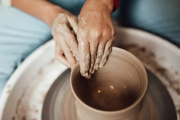 A young woman works in a clay pots workshop.