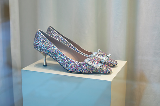 Sparkling shoes on a pedestal, beautiful holiday shoes with rhinestones