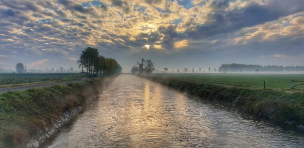 vue panoramique du brouillard sur le canal vacchelli (rivière adda) en novembre au lever du soleil (italie - lombardie - spino d’adda) - river adda photos et images de collection