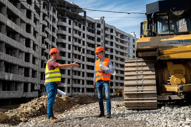 istock two young workers in uniform are considering a project to build a new house 1352256019