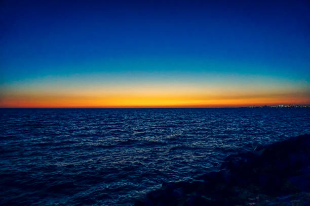 The Ocean in Australia on the stony shore in setting sun.
