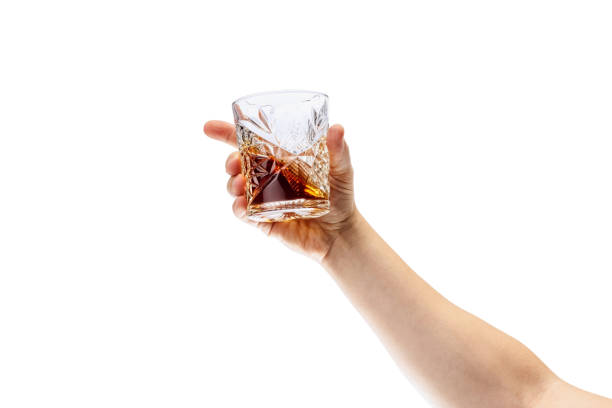istock Cropped image of male hand holding glass with whiskey or rum isolated over white background 1352257241