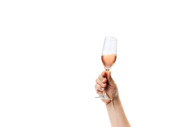 istock Cropped image of male hand holding glass with rose wine isolated over white background 1352257264
