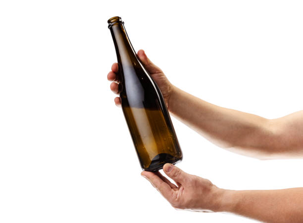 istock Cropped image of male hand holding bottle of white wine isolated over white background 1352257297