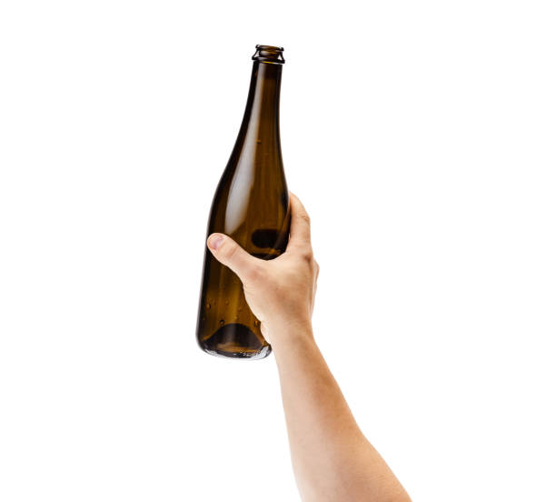 istock Cropped image of male hand holding bottle of white wine isolated over white background 1352257298