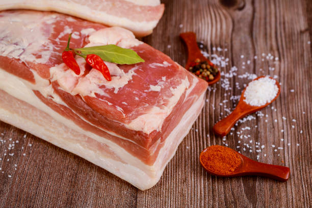 istock One piece of pork belly with spices on wooden background. 1352257471