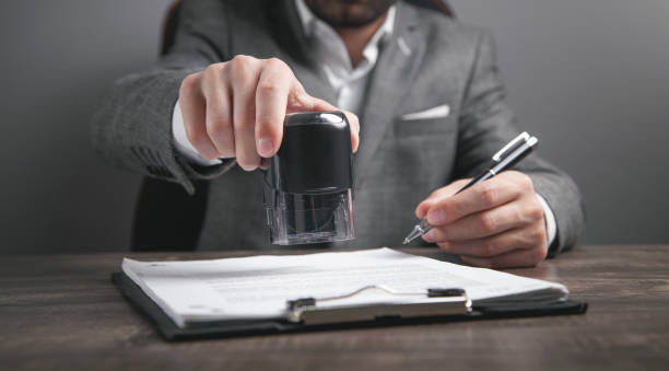 istock Businessman puts a stamp on the documents in the office. 1352258015