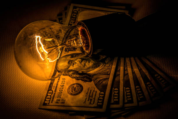 istock Rising electricity prices. Old light bulb and dollar bills 1352259391