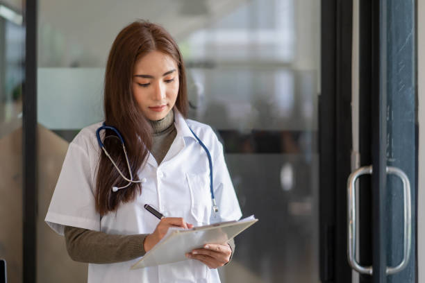 istock Asian female doctor reading document 1352260477