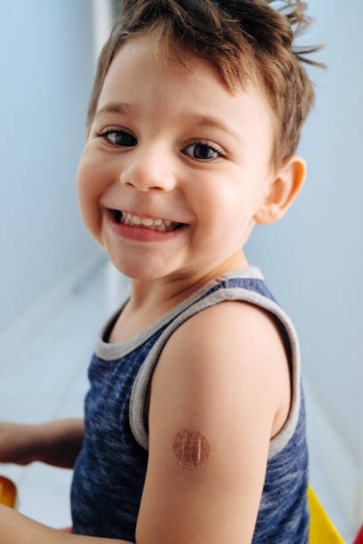 istock Boy showing bandaged arm after getting vaccine 1352261241