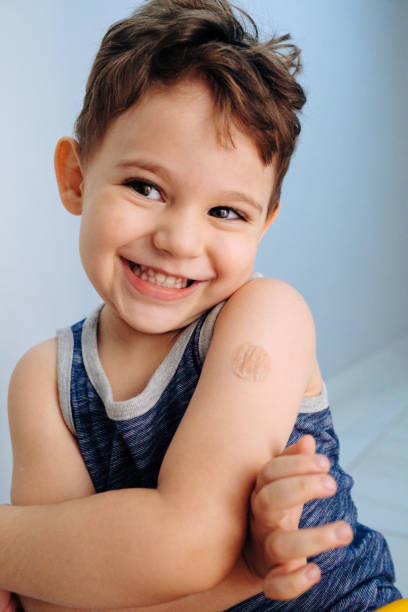 istock Boy showing bandaged arm after getting vaccine 1352262321