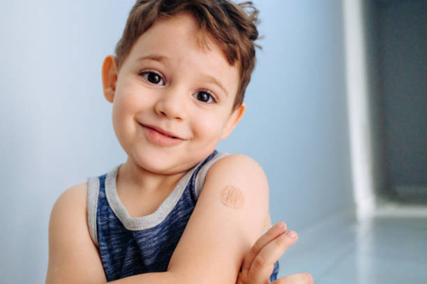 istock Boy showing bandaged arm after getting vaccine 1352262349