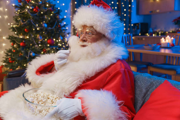 istock Santa Claus is eating popcorn watching TV 1352262351