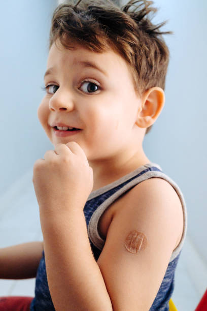 istock Boy showing bandaged arm after getting vaccine 1352262354