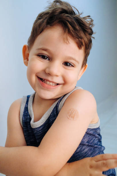 istock Boy showing bandaged arm after getting vaccine 1352262366