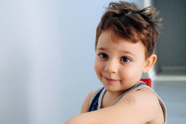 istock Boy showing bandaged arm after getting vaccine 1352262710