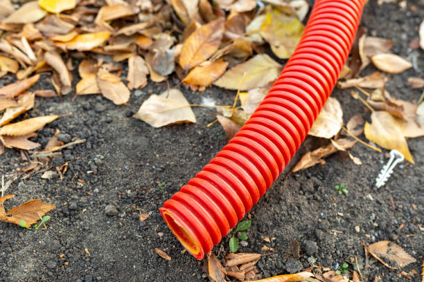 Red corrugated hose for electrical wiring on ground Red corrugated hose for electrical wiring on the ground. Close-up, selective focus pvc conduit stock pictures, royalty-free photos & images