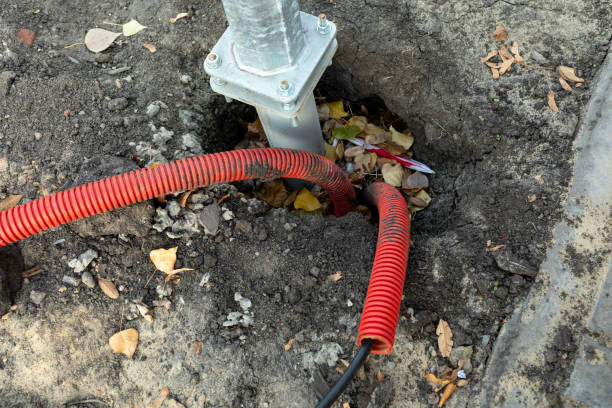 Two red plastic corrugated pipes with wires for bringing electricity to construction site Two red plastic corrugated pipes with wires for bringing electricity to the construction site. Metal pillar fastened to basement with anchor bolts and nuts. The support of the iron pillar. pvc conduit stock pictures, royalty-free photos & images