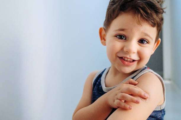 istock Boy showing bandaged arm after getting vaccine 1352262857